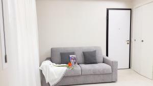 - un canapé gris avec une couverture dans la chambre dans l'établissement Casa Serenissima by Ca-Sa Check, à Chioggia