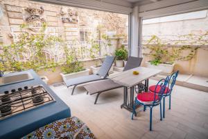 a patio with a table and chairs and a stove at Le Volte Di San Leonardo in Monopoli