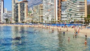 grupa ludzi w wodzie na plaży w obiekcie Apartamento Maysan IF Benidorm w mieście Benidorm