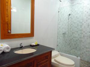 a bathroom with a toilet and a sink and a shower at Griyani Homestay in Uluwatu