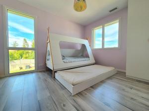 une chambre avec un lit dans une pièce avec des fenêtres dans l'établissement La Villa du Chêne, à Hombourg