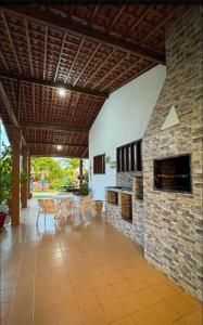 a patio with a stone fireplace and a table and chairs at Chácara Amsterdam in Aracaju