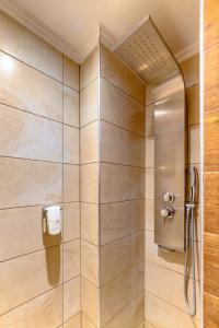 a shower with a glass door in a bathroom at Ikies Luxury Apartments in Ofrínion