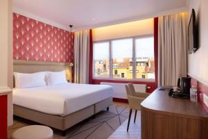 a hotel room with a bed and a desk at Hotel The Augustin in Brussels