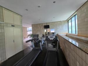 a gym with a bench in the middle of a room at Apart Hotel Volpi 101 - Conforto & Comodidade in Belo Horizonte