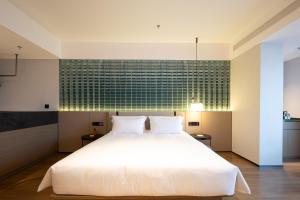 Voodi või voodid majutusasutuse Liangzhi Huipin Hotel Haikou West Coast Yongwan Road Branch toas