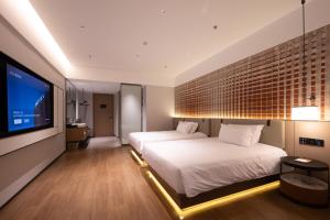Voodi või voodid majutusasutuse Liangzhi Huipin Hotel Haikou West Coast Yongwan Road Branch toas
