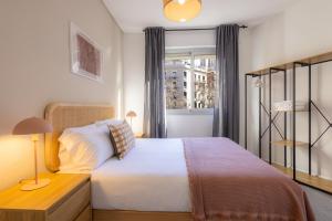 Un dormitorio con una cama grande y una ventana. en Stay U-nique Apartment Rossello II, en Barcelona