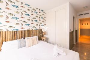 a bedroom with a bed and a wall with fish on it at Apartment El Sol in Moraira +18 photos