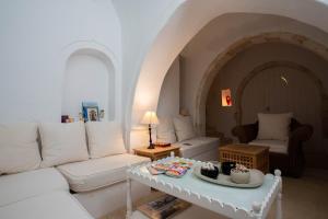 a living room with a white couch and a table at La Maison Blanche -Les Houchs De Djerba in Erriadh