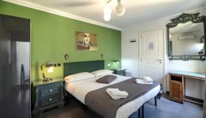 een slaapkamer met een groot bed met groene muren bij Mimì Terrace in Napels