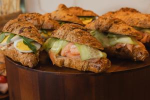 a group of sandwiches on a wooden plate at Hotel Marco Polo in Lido di Jesolo