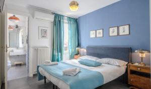 een blauwe slaapkamer met een bed met 2 kussens erop bij Mimì Terrace in Napels