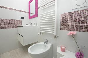 a white bathroom with a sink and a toilet at Guest House Genova Holiday in Genova +4 photos