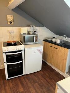 eine Küche mit Herd und Mikrowelle in der Unterkunft rhyl apartments in Rhyl