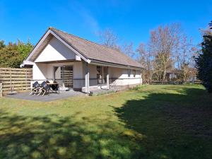 FormerumMolkenbos Terschelling的院子内带桌子的白色小房子