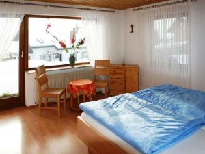 a bedroom with a bed and a table and a window at Haus Schwarzwald in Furtwangen