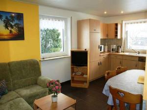 a living room with a couch and a table and a kitchen at Haus Schwarzwald in Furtwangen