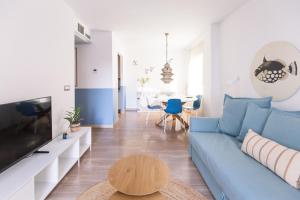 a living room with a blue couch and a table at Apartment El Sol in Moraira