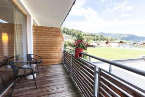 un balcone con 2 sedie e una pentola di fiori di Revier Hotel Kaprun a Kaprun