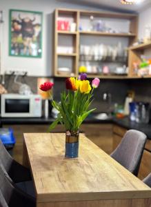 eine Vase voller Blumen auf einem Tisch in der Unterkunft Mouse House in Chişinău