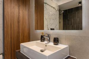 a bathroom with a white sink and a mirror at Luxury Landing Apartments Complex Qualis Brasov in Braşov