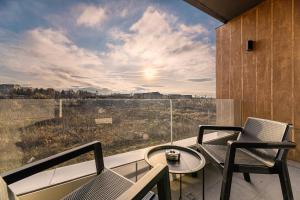 a balcony with chairs and a table and a view at Luxury Landing Apartments Complex Qualis Brasov in Braşov