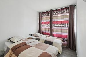 Dos camas en una habitación con una bandera estadounidense en la ventana. en Chic and spacious apart with parking, en Colombes