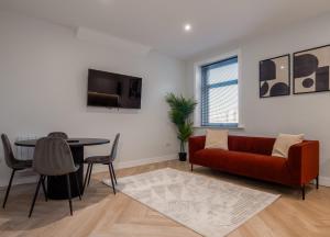 a living room with a red couch and a table at Dwell Living North Bridge Apartments in Sunderland
