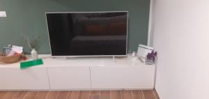 a flat screen tv on a white entertainment center at Reef Mondello Apartment in Palermo