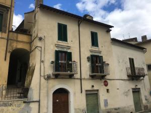 a white building with green shutters and a door at Il castelluccio in Gallese