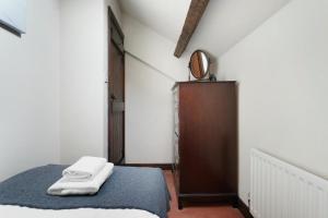 a bedroom with a bed with two towels on it at Sunny Brow Cottage at Thompson Ground in Hawkshead