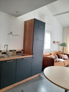 una cucina con un grande frigorifero e un soggiorno di Lucie City Lodge Clermont-Ferrand a Clermont-Ferrand