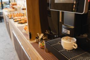 a coffee machine sitting on a counter with a coffee cup at Hotel Marco Polo in Lido di Jesolo