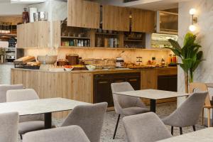 a restaurant with tables and chairs and a kitchen at Hotel Marco Polo in Lido di Jesolo