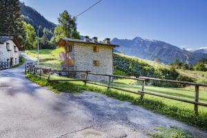 a house on the side of a road next to a fence at Chalet la Mia Baita 2 - AffittiPontediLegno in Ponte di Legno +7 photos