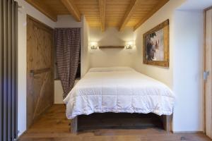 a bedroom with a bed and a wooden ceiling at Chalet la Mia Baita 2 - AffittiPontediLegno in Ponte di Legno