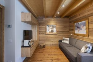 a living room with a couch and a tv at Chalet la Mia Baita 2 - AffittiPontediLegno in Ponte di Legno
