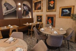 a restaurant with tables and chairs and pictures on the wall at Hotel Marco Polo in Lido di Jesolo
