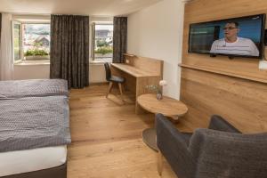 a hotel room with a bed and a flat screen tv at Gasthaus Rössli in Gipf-Oberfrick