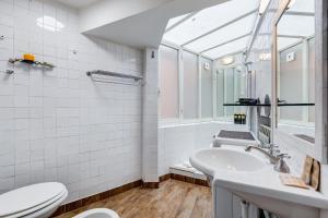 une salle de bain avec un lavabo et des toilettes dans l'établissement Vivilo Collection - Macelli Spanish Steps Apartment, à Rome 47 autres photos