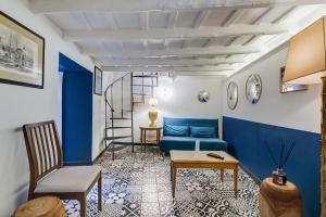 un salon avec un canapé bleu et une table dans l'établissement Vivilo Collection - Macelli Spanish Steps Apartment, à Rome