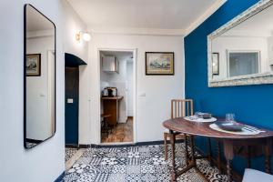 une salle à manger avec une table et un mur bleu dans l'établissement Vivilo Collection - Macelli Spanish Steps Apartment, à Rome
