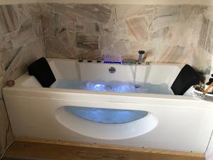 une baignoire remplie d'eau bleue dans une salle de bain dans l'établissement Mauthnerhube Ferienwohnung mit Sauna, Whirlpool, Hüttenfeeling, à Sankt Oswald ob Eibiswald 42 autres photos