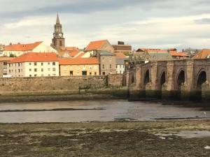 a bridge over a river with a city in the background at Town Centre Apartment in Berwick-Upon-Tweed