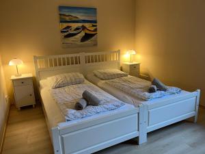 a bedroom with two beds with pillows and two lamps at Gemütliche strandnahe Ferienwohnung in Bansin