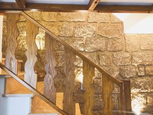 a wooden staircase in front of a stone wall at Laje House Fireplace Entire House Wifi in Fundão +6 photos