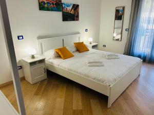 a bedroom with a large white bed with orange pillows at Grazia Luxury Home in Verona