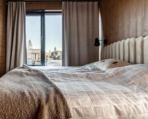 a bedroom with a large bed with a window at Luxury apartment, 8 beds, sauna, 10 min to ski slopes in Idre