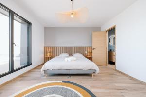 a bedroom with a bed and a large window at Villa Bellevue in Donville-les-Bains +69 photos